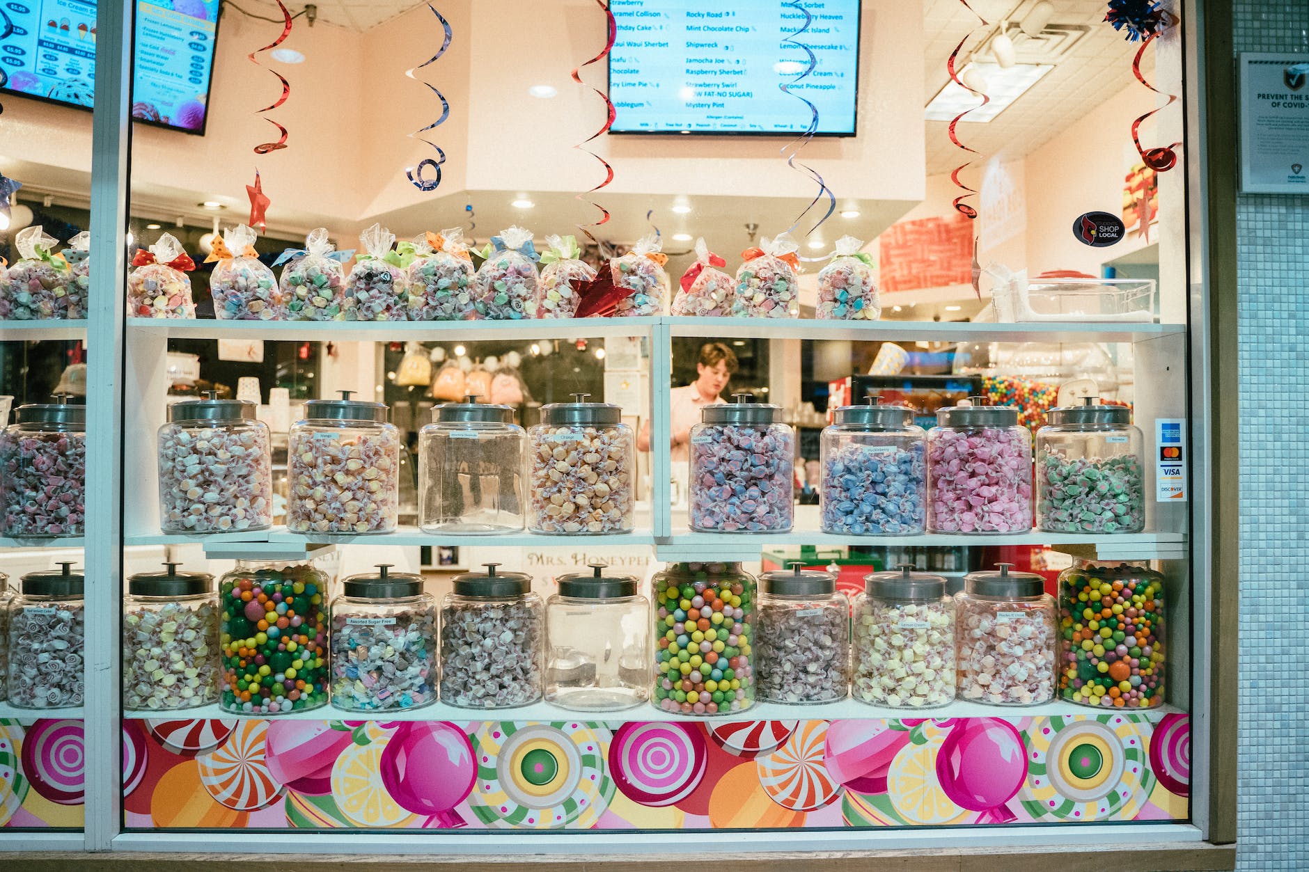 assorted candies in glass jars display on store
