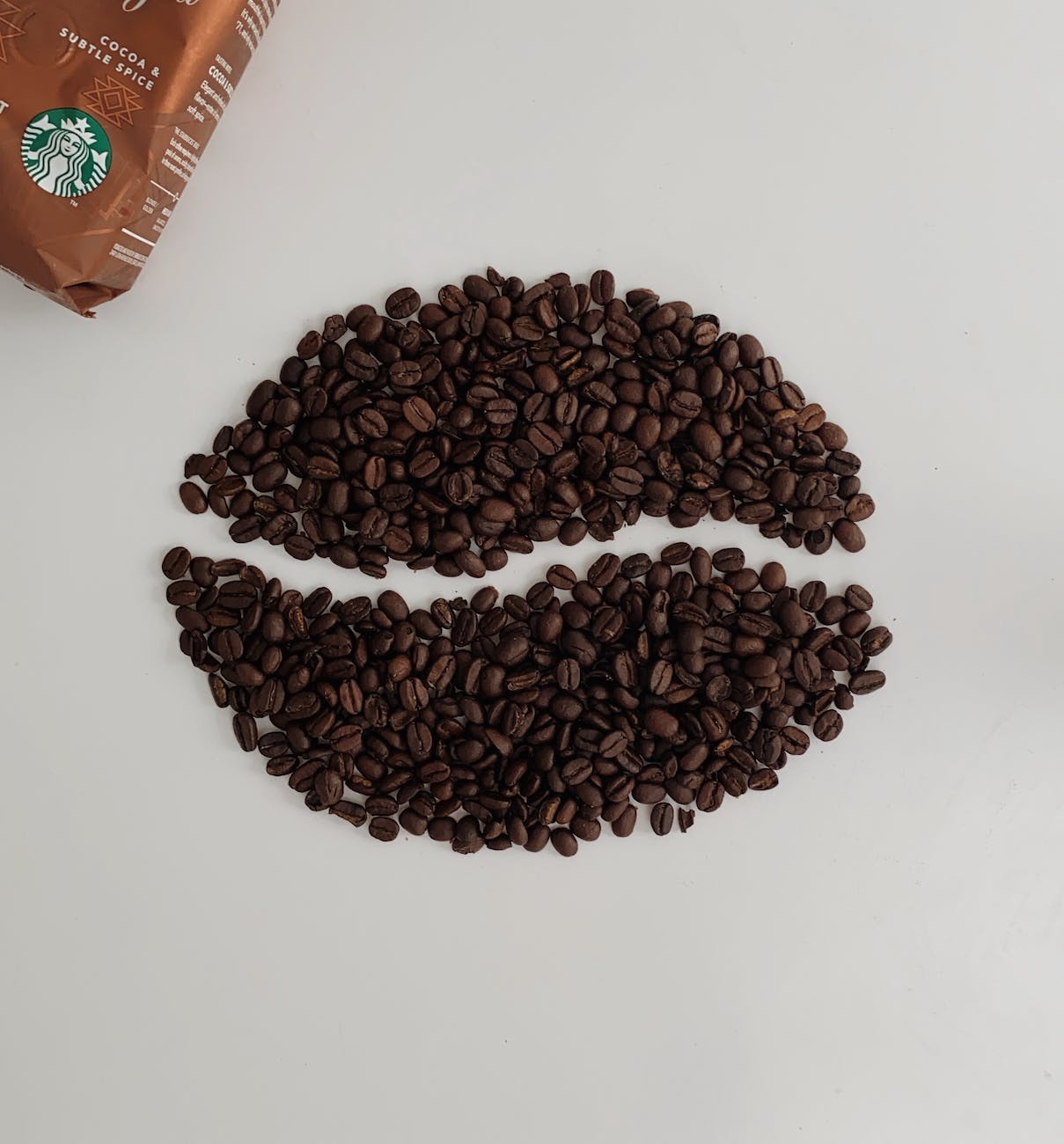 aromatic coffee beans near package on white background