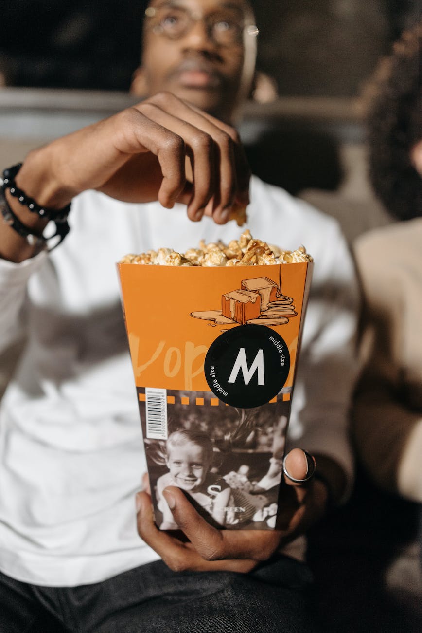 photo of a man holding a bucket of caramel popcorn